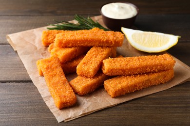 Photo of Fresh breaded fish fingers served on wooden table