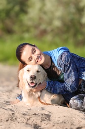 Young woman with her dog together on beach. Pet care