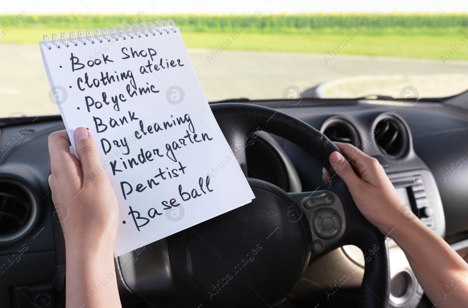 Photo of Woman with to do list in driver's seat of car, closeup. Stress overload concept