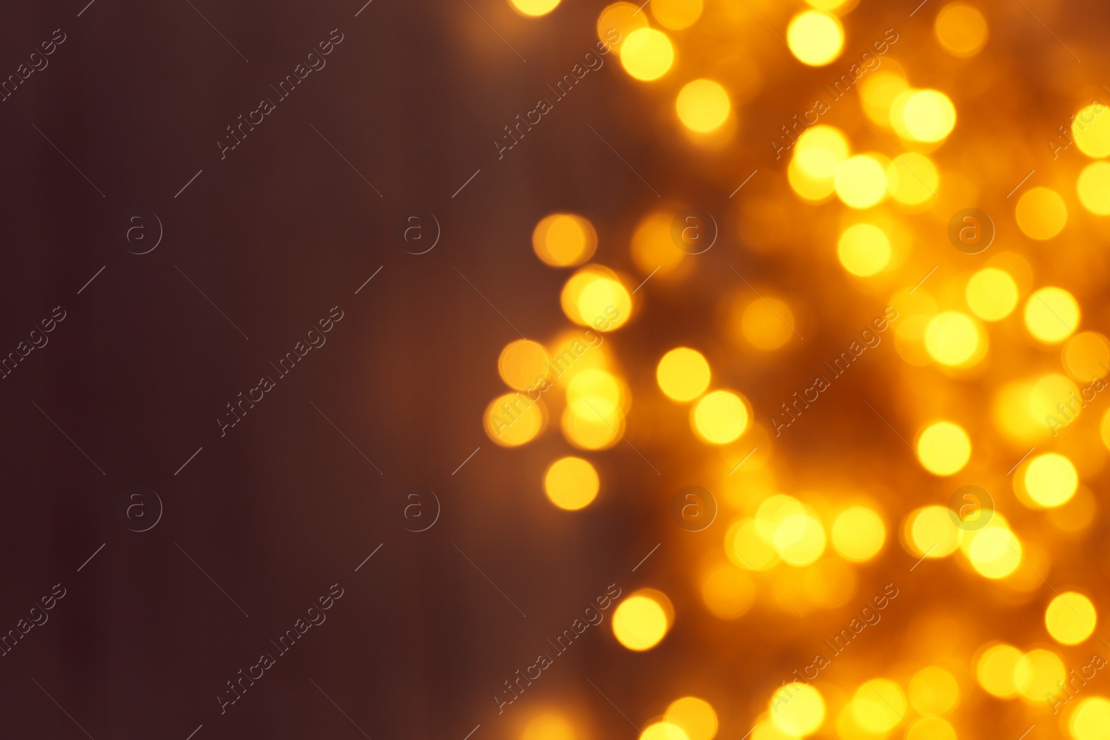 Photo of Blurred view of Christmas lights on dark background, space for text