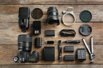 Photo of Flat lay composition with equipment for professional photographer on wooden table