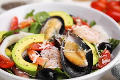 Photo of Bowl of delicious salad with seafood, closeup view