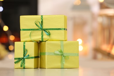 Photo of Beautifully wrapped gift boxes against blurred festive lights. Christmas celebration