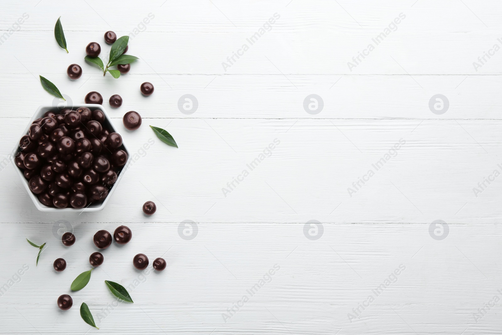 Photo of Flat lay composition with tasty acai berries on white wooden table. Space for text