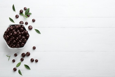 Flat lay composition with tasty acai berries on white wooden table. Space for text