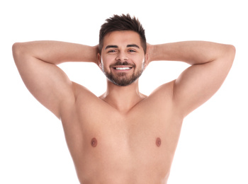 Photo of Young man showing hairless armpits after epilation procedure on white background