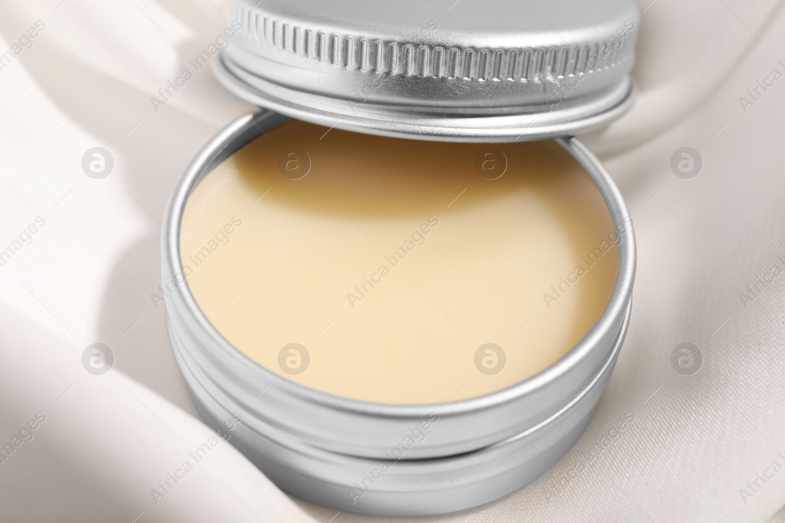 Photo of Lip balm on white fabric, closeup view