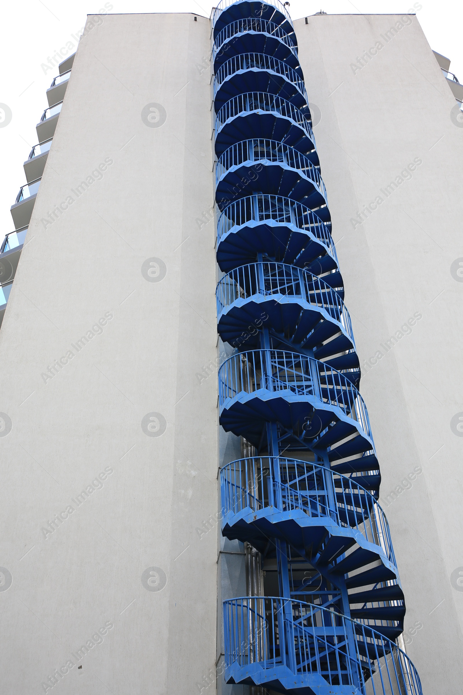 Photo of View of modern metal empty fire escape ladder near building outdoors