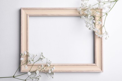 Wooden frame with beautiful gypsophila flowers on white background, top view. Space for text