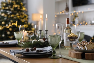 Christmas table setting with festive decor and dishware in room