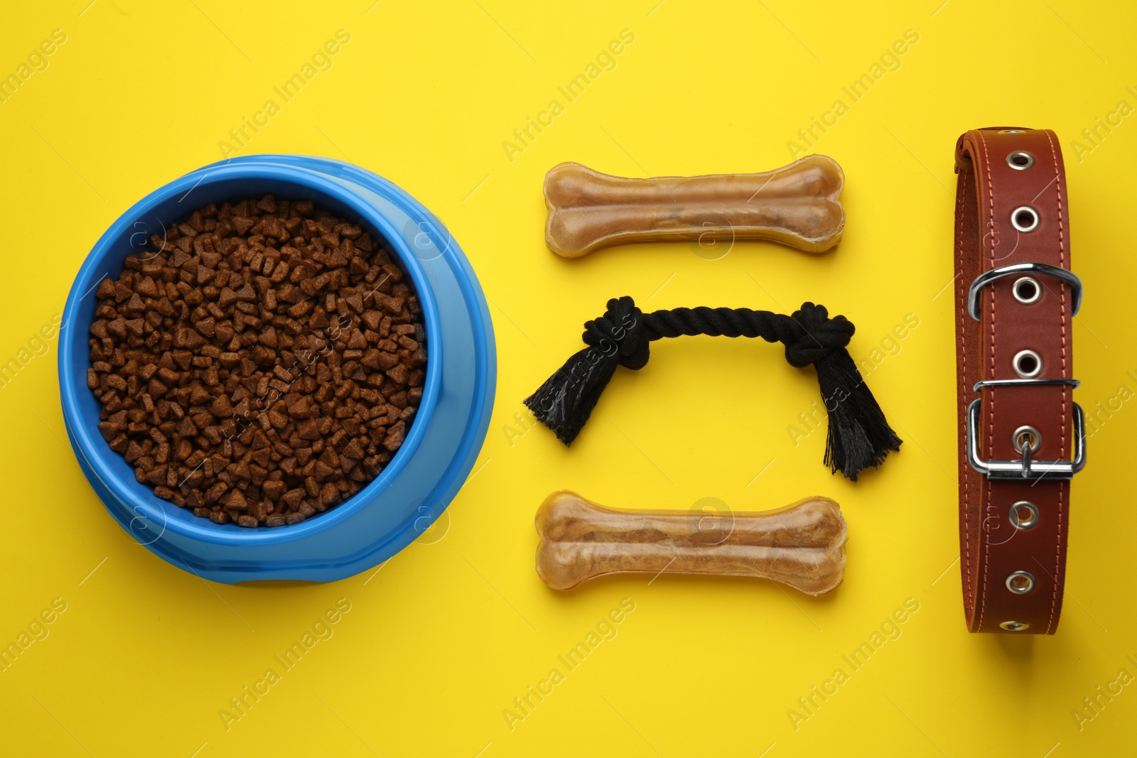 Photo of Flat lay composition with pet toys and feeding bowl on yellow background