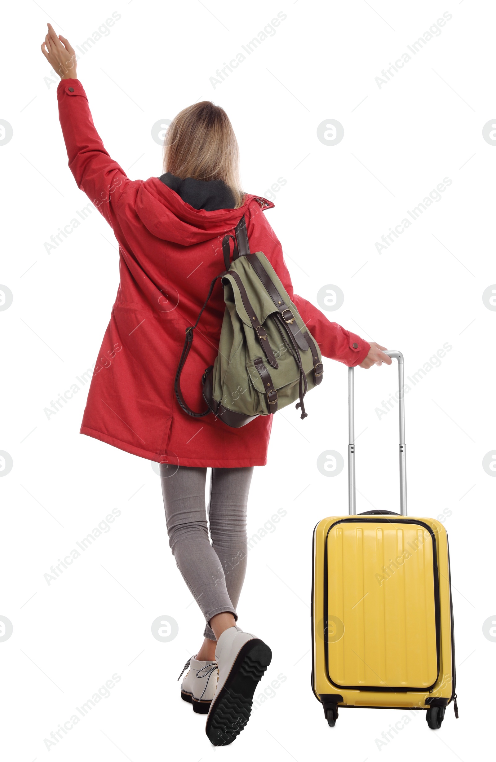 Photo of Woman with suitcase walking on white background, back view. Winter travel