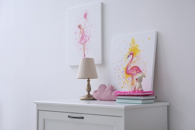 Chest of drawers and beautiful pictures in children's room. Interior design