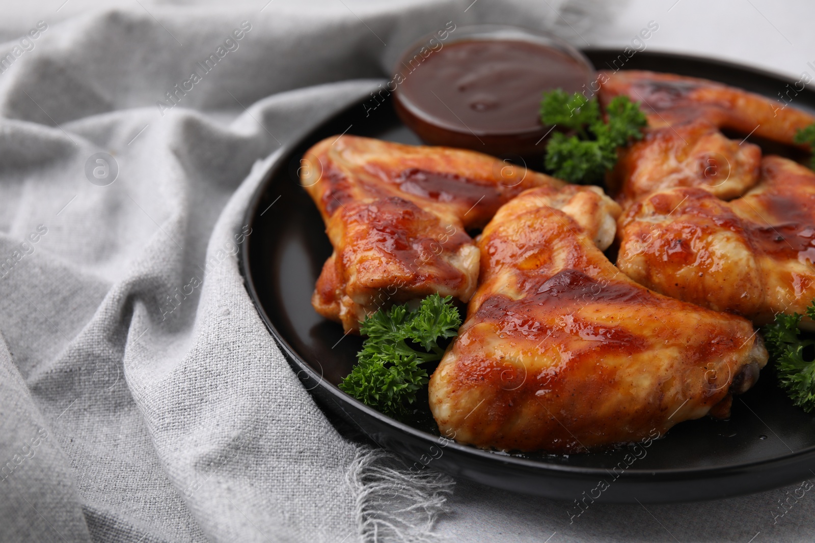 Photo of Fresh marinade and chicken wings on light table, closeup