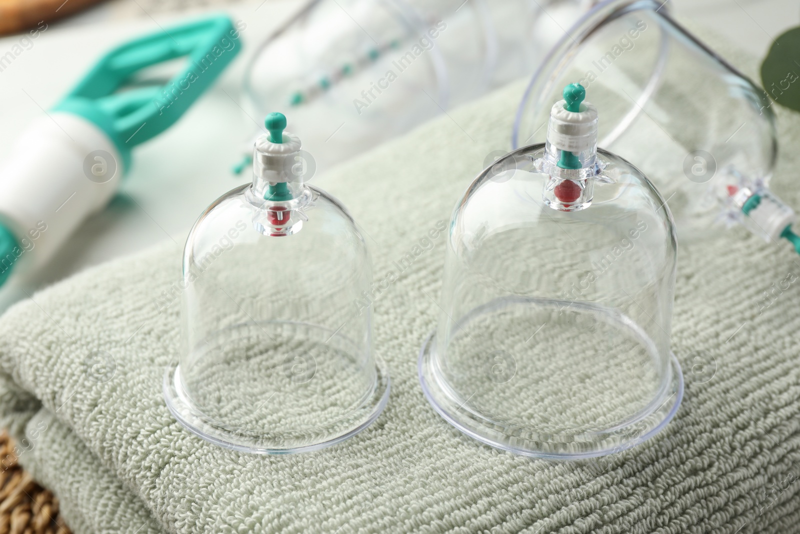 Photo of Cupping therapy. Plastic cups on soft towel, closeup