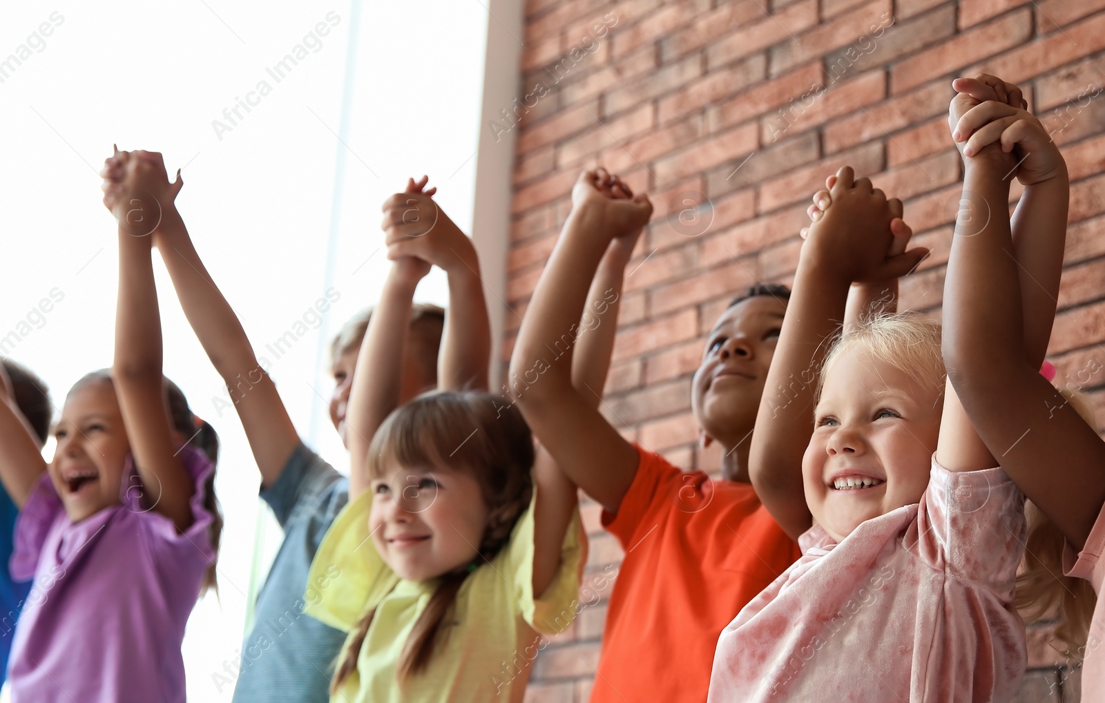 Photo of Little children holding hands together indoors. Unity concept