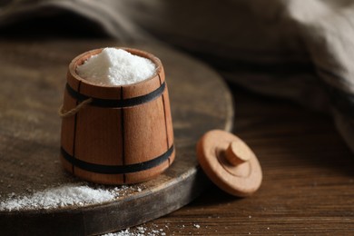 Photo of Organic salt in bowl on wooden table. Space for text