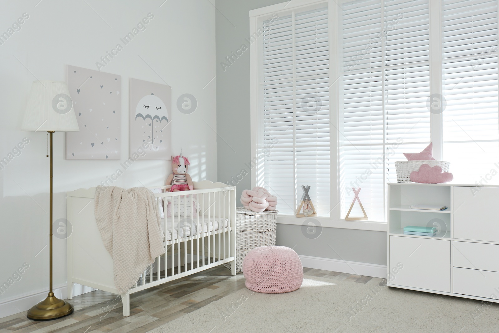 Photo of Stylish baby room interior with crib and cute pictures on wall