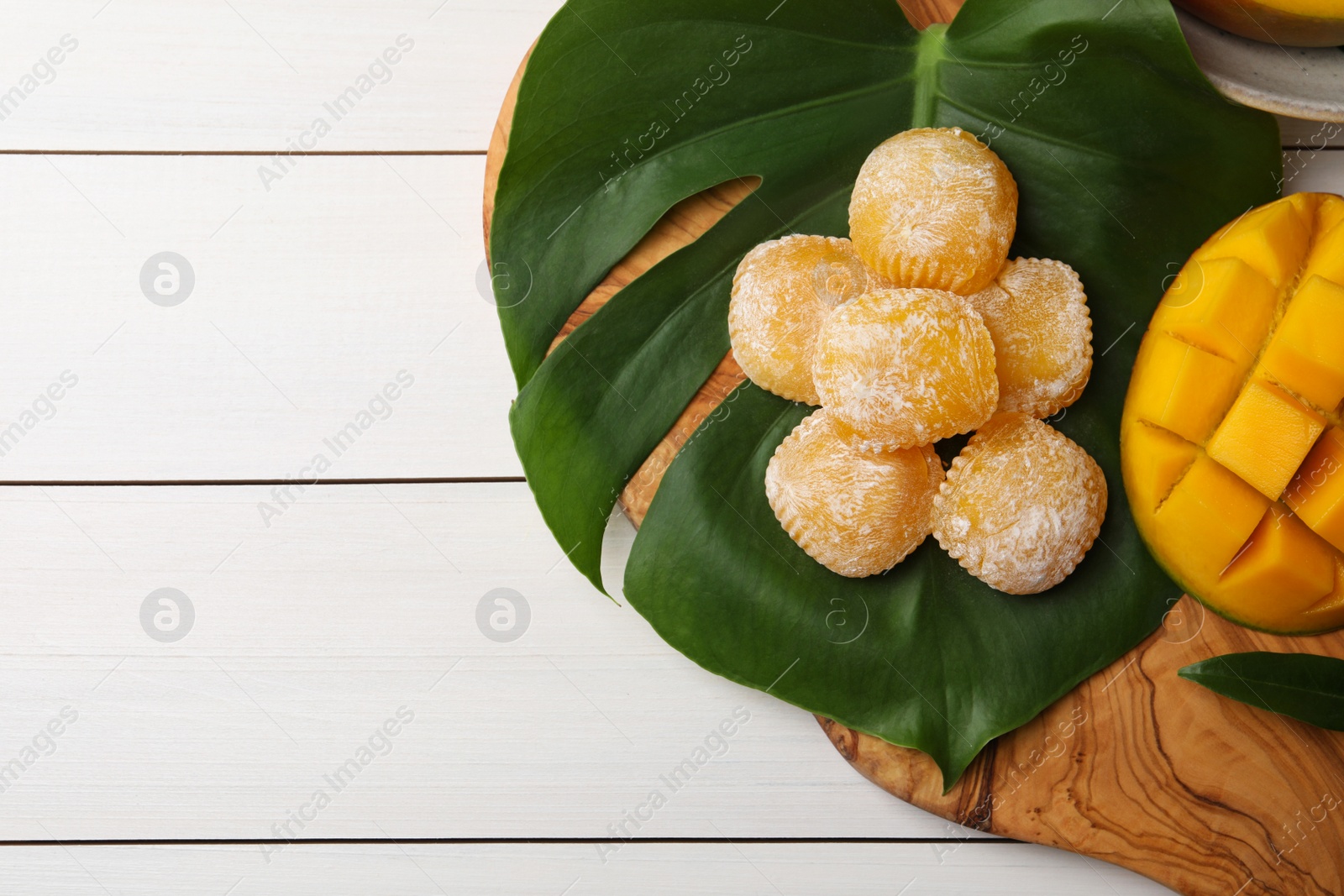 Photo of Flat lay composition with delicious mochi and mango on white wooden table, space of text. Traditional Japanese dessert