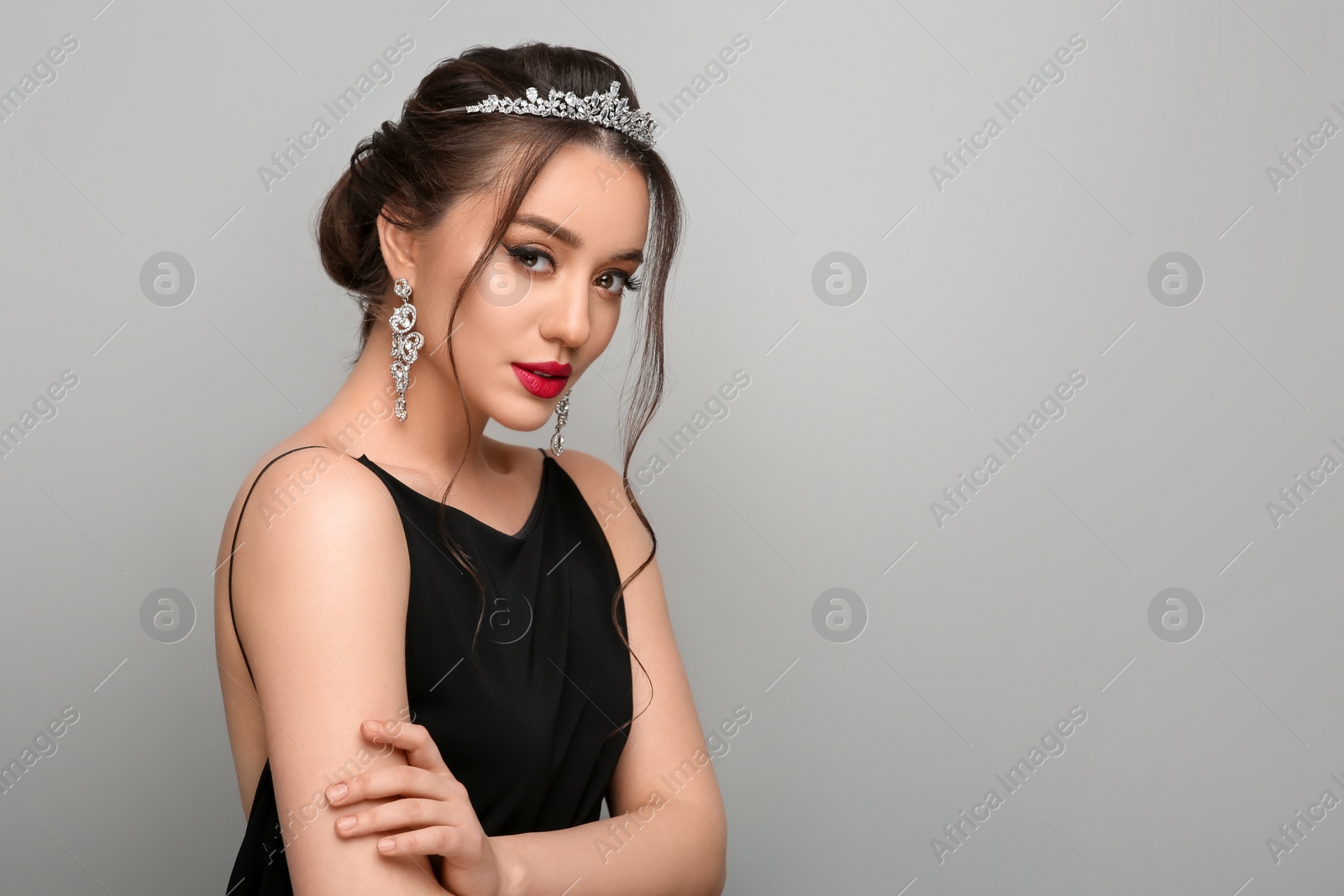 Photo of Beautiful young woman wearing luxurious tiara on light grey background, space for text