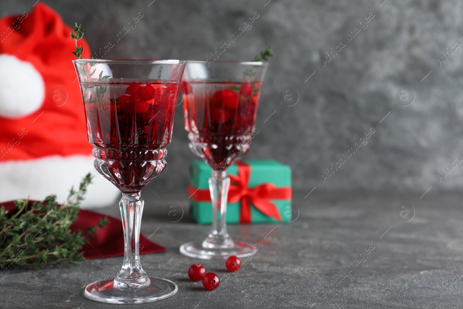 Photo of Delicious Christmas cocktail with liqueur on grey table. Space for text