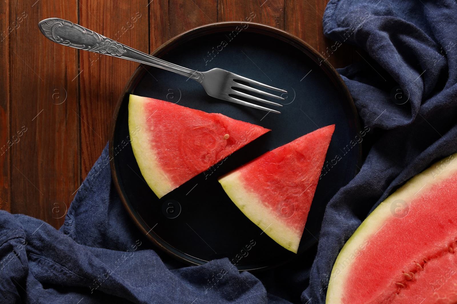 Photo of Sliced fresh juicy watermelon served on wooden table, flat lay