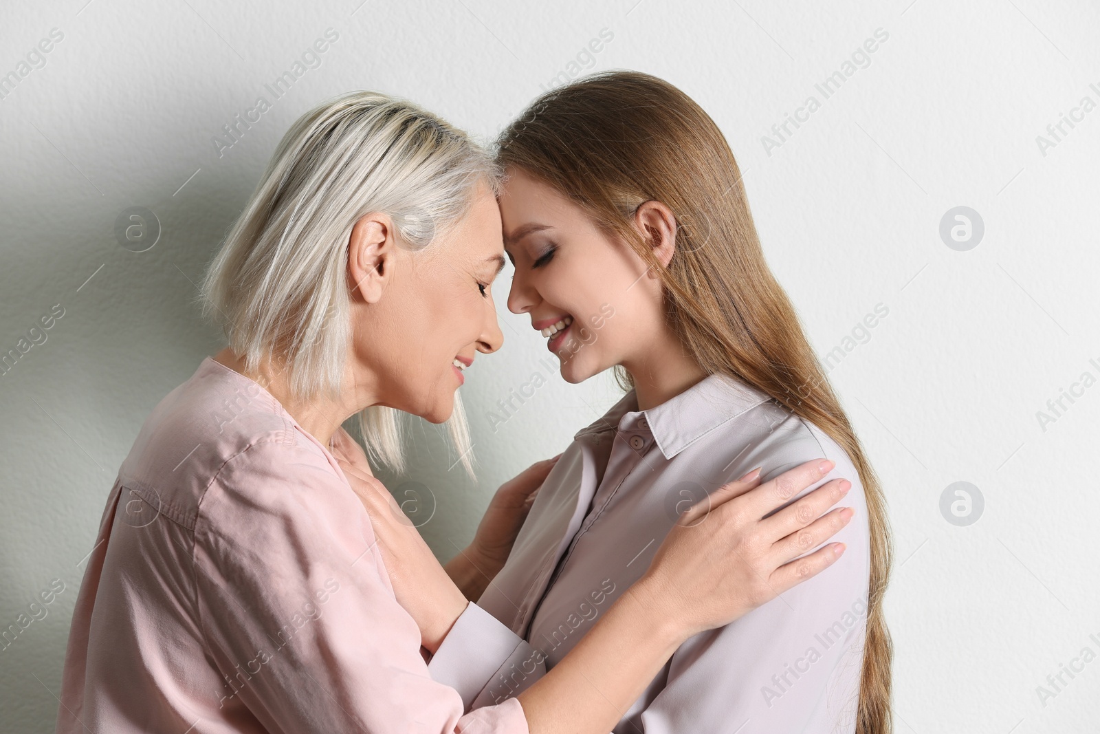 Photo of Mother and her adult daughter on white background