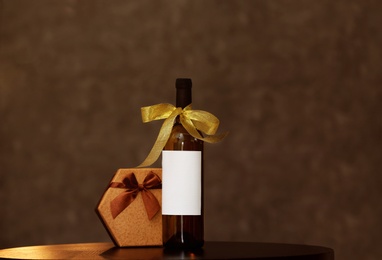 Gift box and bottle of wine on table. Space for design