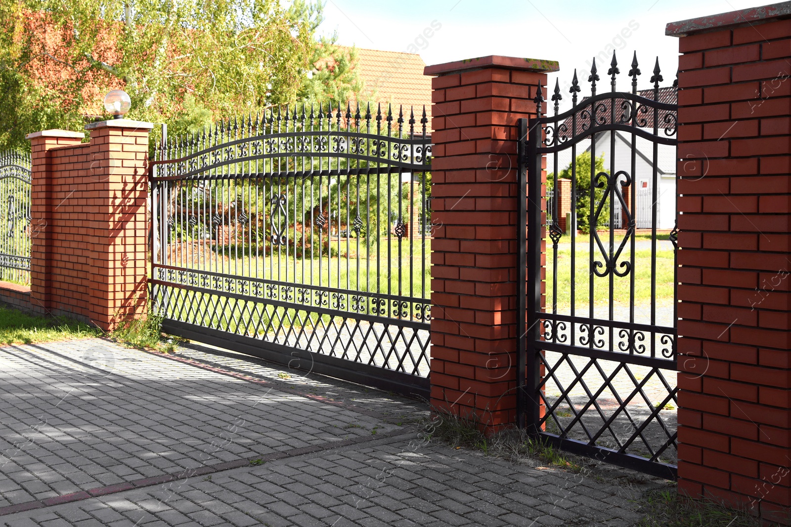 Photo of Closed metal gates near houses and trees