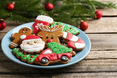 Photo of Different tasty Christmas cookies and fir tree branches on wooden table, closeup. Space for text