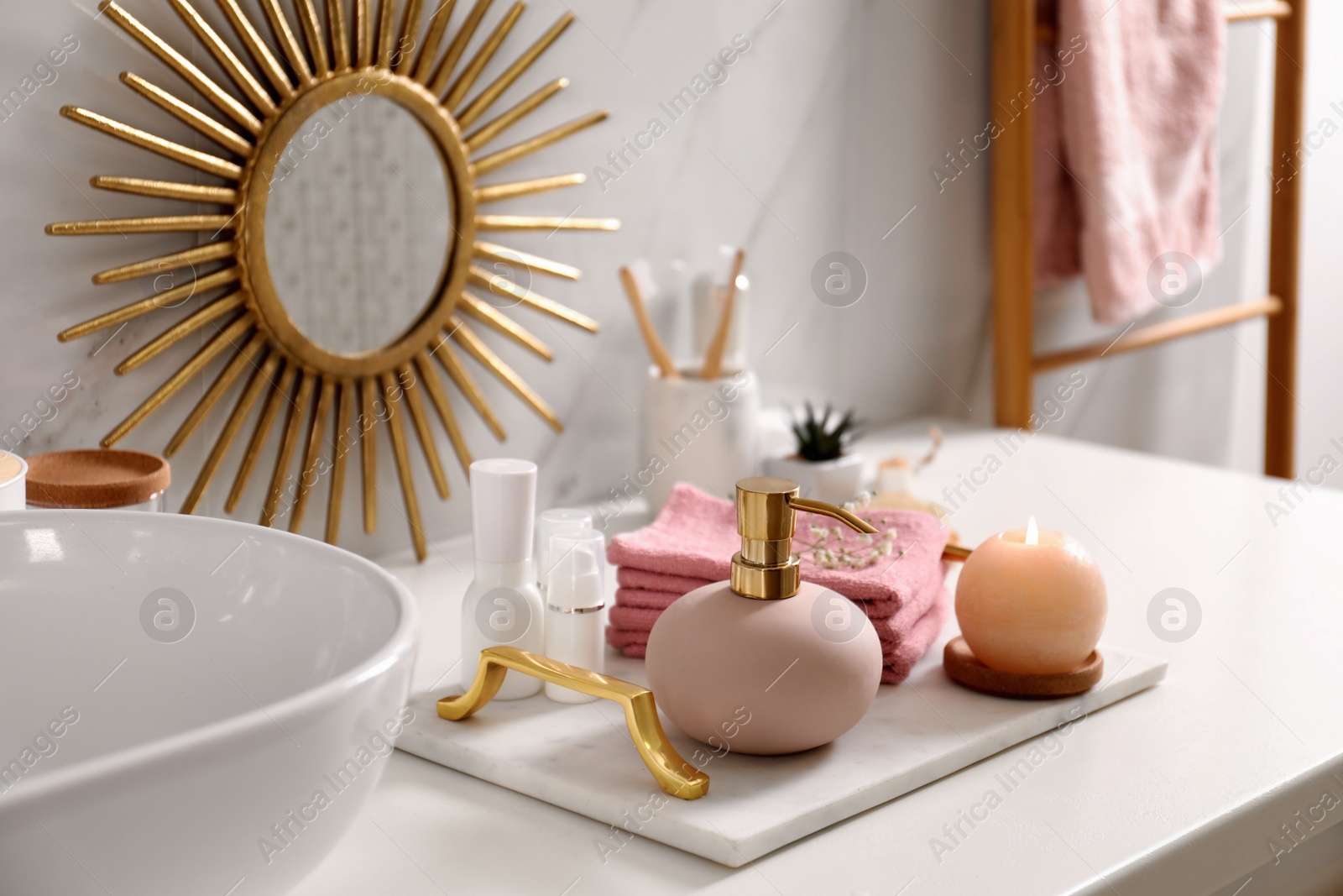 Photo of Tray with different toiletries, burning candle and towels near vessel sink in bathroom