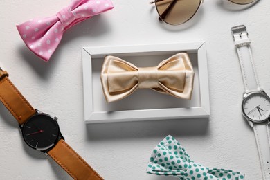 Photo of Stylish color bow ties and wristwatches on white background, flat lay