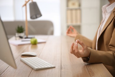 Photo of Woman meditating at workplace in office, closeup. Space for text