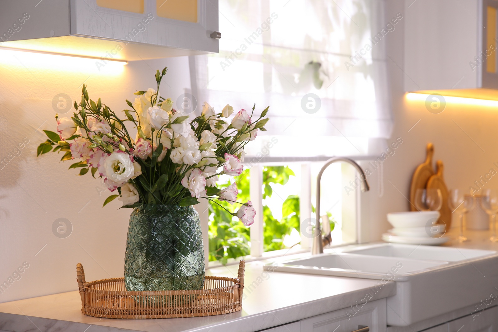 Photo of Bouquet of beautiful flowers on countertop in kitchen, space for text. Interior design