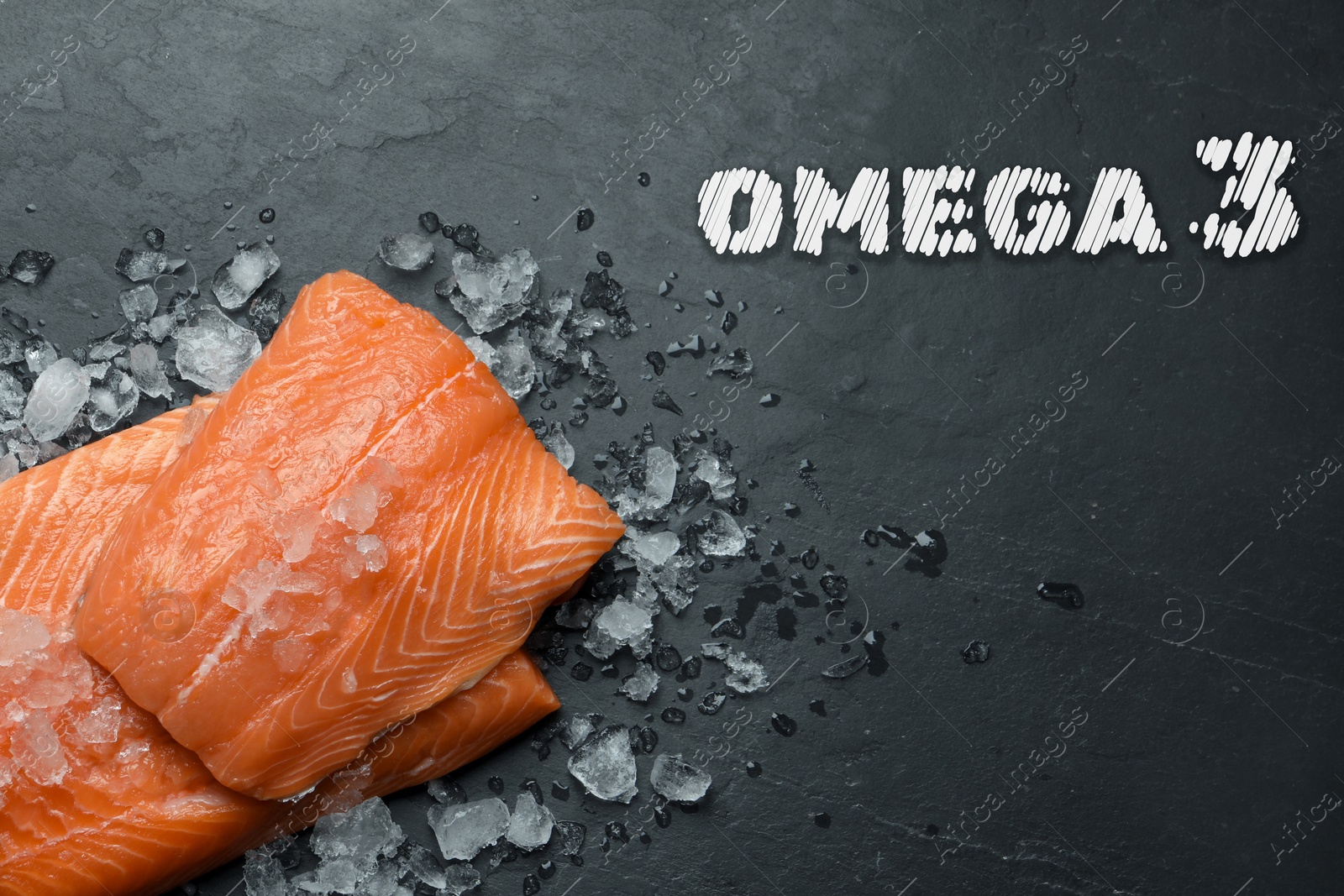 Image of Omega 3. Fresh cut salmon and ice on black table, top view