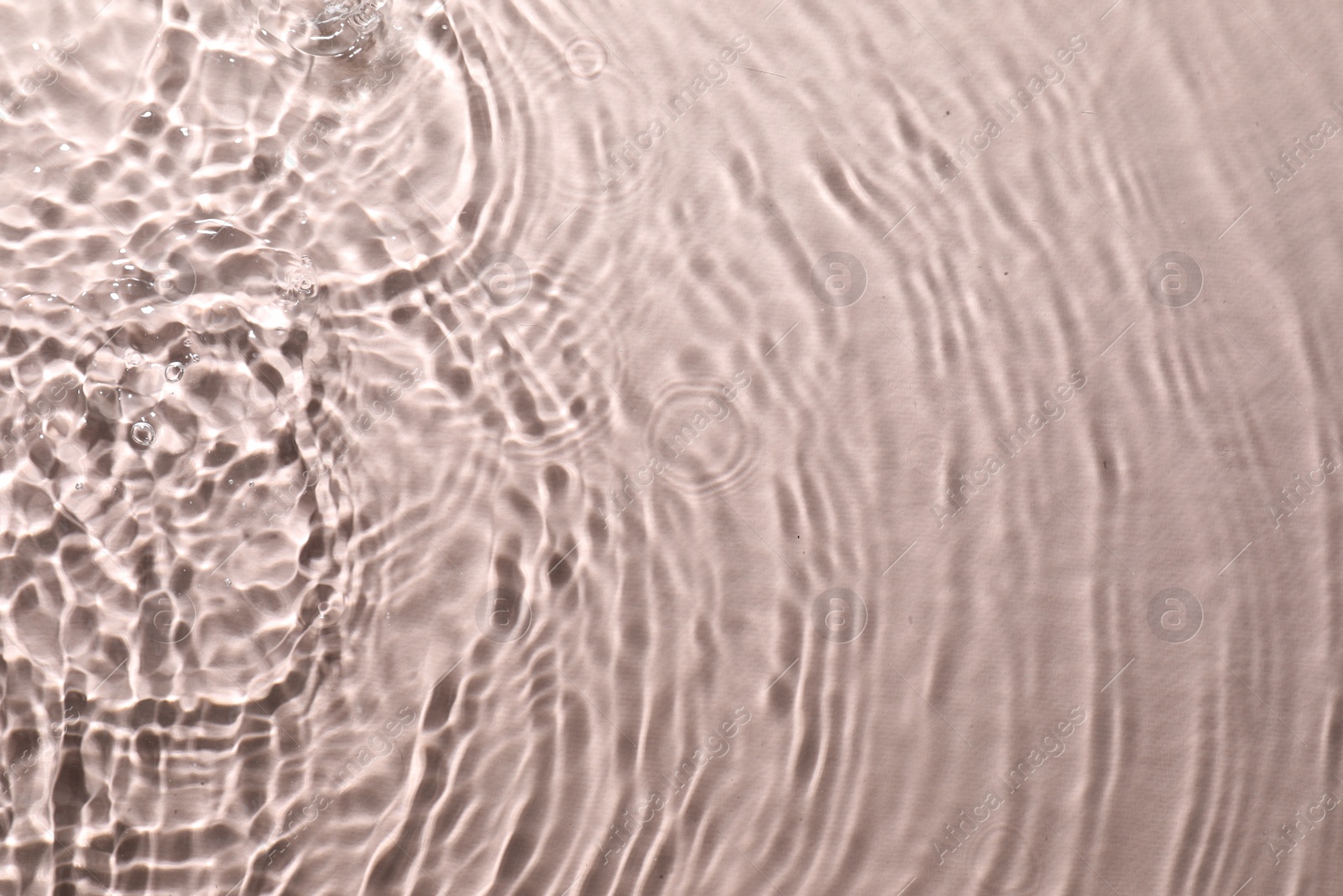 Photo of Rippled surface of clear water on beige background, top view