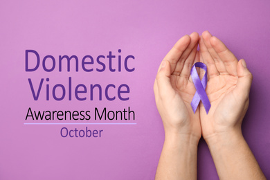 Image of Woman holding purple ribbon on lilac background, top view. Symbol of Domestic Violence Awareness