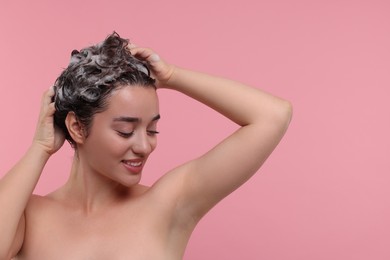 Photo of Beautiful happy woman washing hair on pink background. Space for text