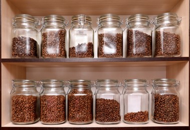 Glass jars with coffee beans on rack