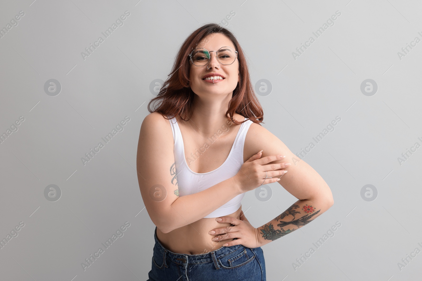 Photo of Portrait of beautiful tattooed woman on gray background