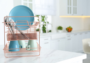 Photo of Clean dishes on drying rack in modern kitchen interior, space for text