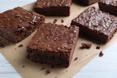 Delicious chocolate brownies on white wooden table, closeup