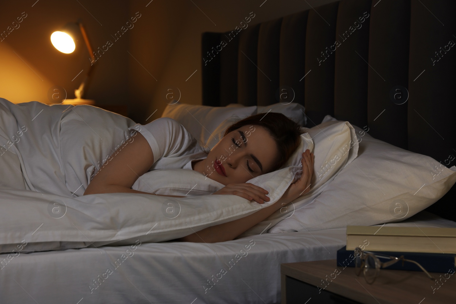 Photo of Beautiful young woman sleeping in bed at night