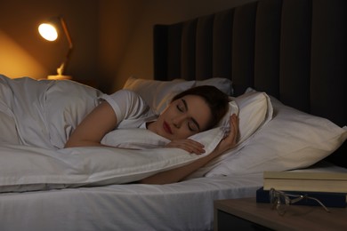 Beautiful young woman sleeping in bed at night