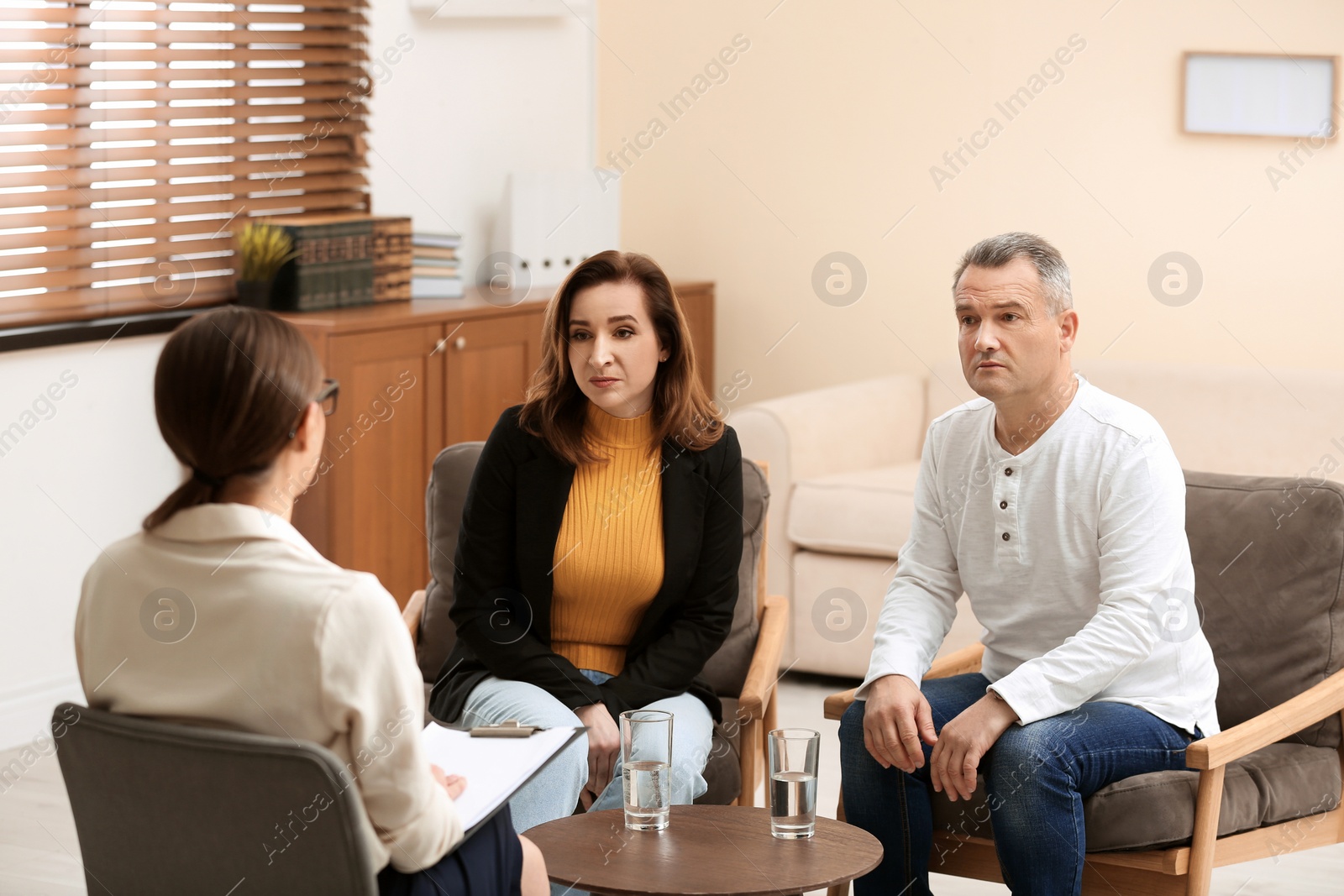 Photo of Psychotherapist working with couple in office. Family counselling