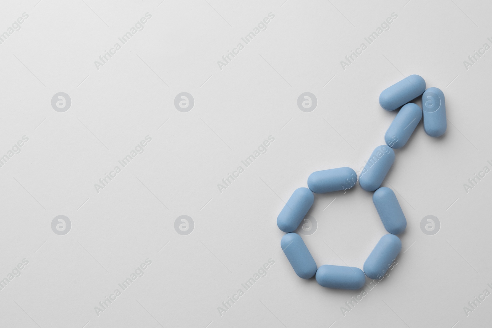 Photo of Male sign made of pills and space for text on white background, top view. Potency problem