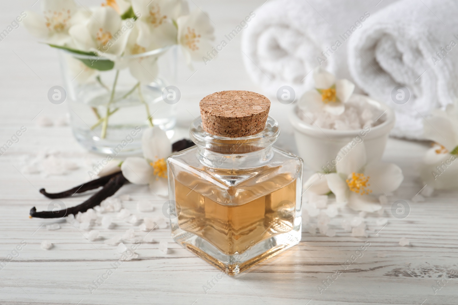 Photo of Beautiful composition with jasmine essential oil and fresh flowers on white wooden table