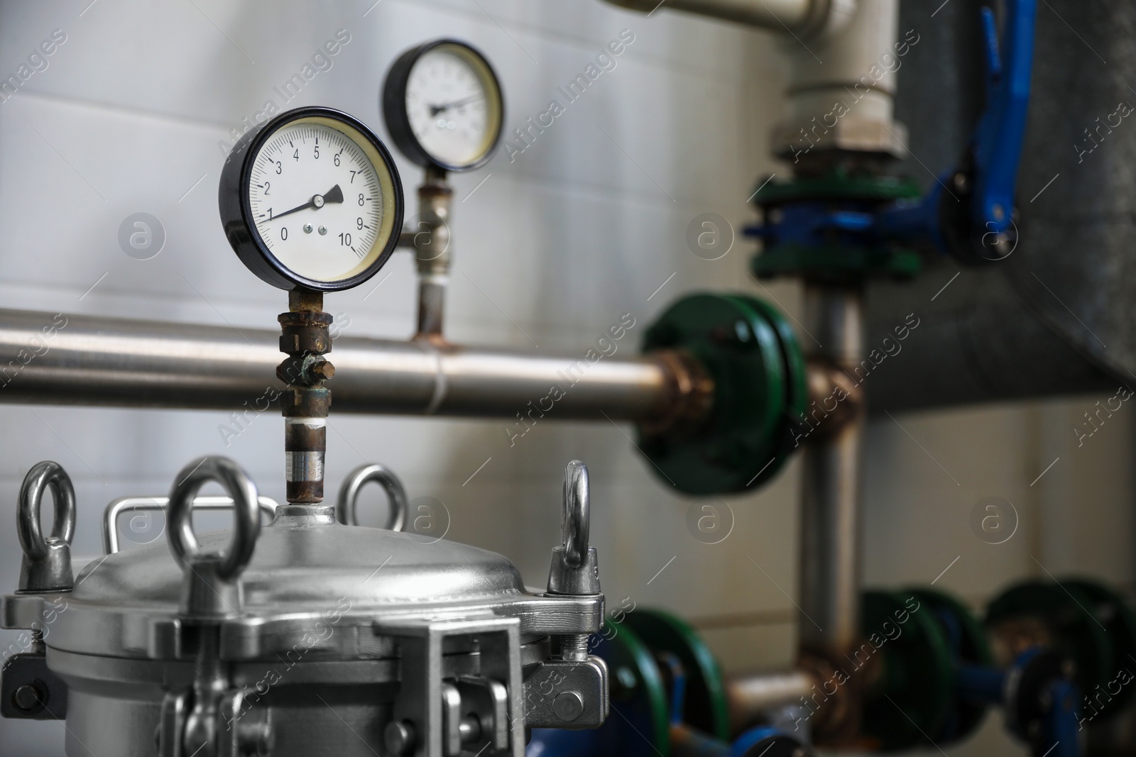 Photo of Pressure gauges and pipes indoors, space for text. Production machinery at modern granary