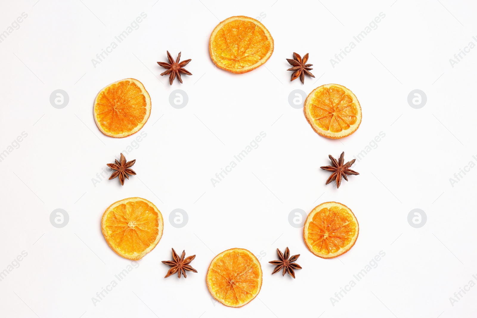 Photo of Frame made of dry orange slices and anise stars on white background, flat lay with space for text