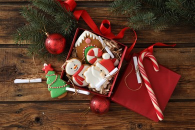 Photo of Christmas cookies in gift box and festive decor on wooden table, flat lay. Advent calendar